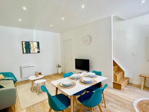 a dining room and living room with a table and chairs at *ARENA* - duplex lumineux in Reims