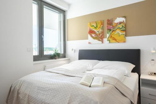 Un dormitorio con una cama con dos libros. en FeelGood Apartments LakeLiving inklusive Garagenplatz, en Viena