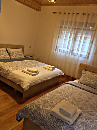 two beds in a bedroom with towels on them at Bar Restaurant Hotel ''Te Gusti'' in Tamarë