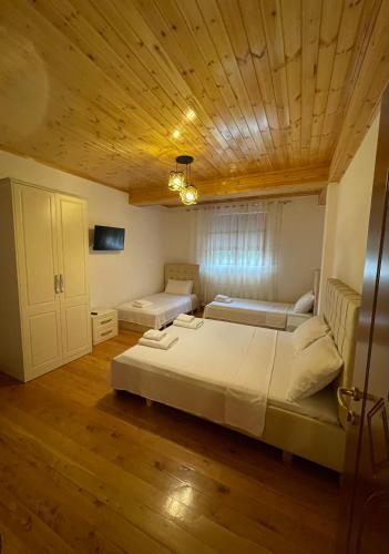 a bedroom with two beds and a wooden ceiling at Bar Restaurant Hotel ''Te Gusti'' in Tamarë