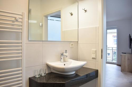uma casa de banho com um lavatório e um espelho em Weingut Lindenhof Kröhler 