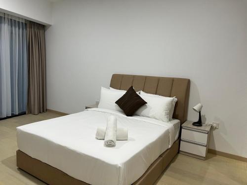 1 dormitorio con 1 cama blanca grande y 2 toallas en Eaton Suites KLCC, en Kuala Lumpur