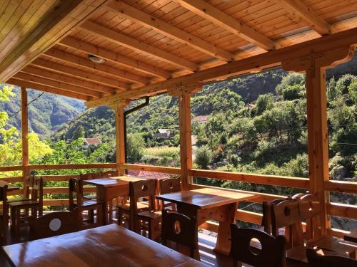 Habitación con mesas, sillas y ventana grande. en Bar Restaurant Hotel ''Te Gusti'' en Tamarë