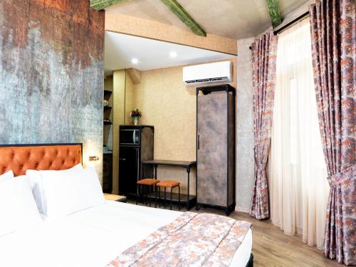 um quarto de hotel com uma cama e uma secretária em 6 Unique Apartments em Tbilisi