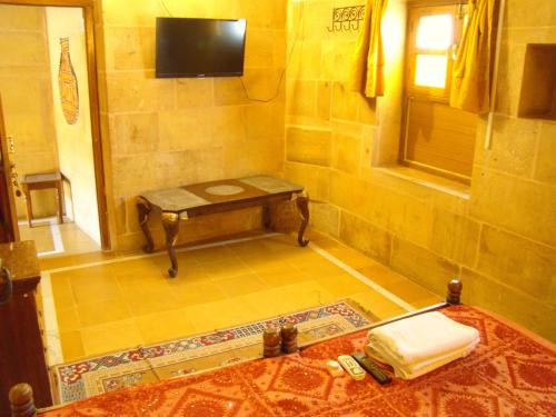 a bathroom with a table and a tv on the wall at Shahi Palace Hotel Jaisalmer in Jaisalmer