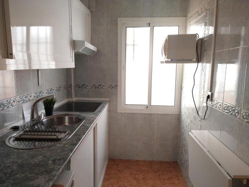 uma cozinha com um lavatório e uma janela em Coqueto miniapartamento junto centro Torremolinos em Torremolinos