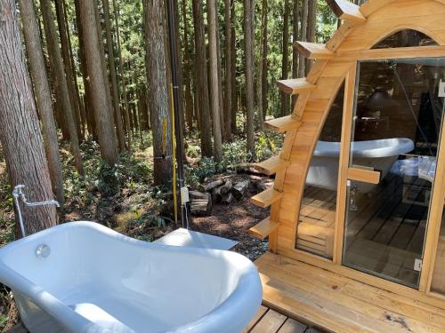 une cabane dans les arbres avec une baignoire dans les bois dans l'établissement North Villge Hirugano - Vacation STAY 32983v, à Gujō
