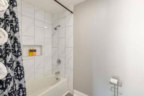 a white bathroom with a tub and a shower at 4 Bed 3 Bath House, Spacious, Smart TVs in all rooms, Whole house to yourself in Garland