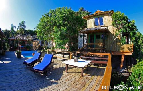 una casa en un árbol en una terraza con sillas y una mesa en Pousada Casa do Ceo, en Praia do Rosa
