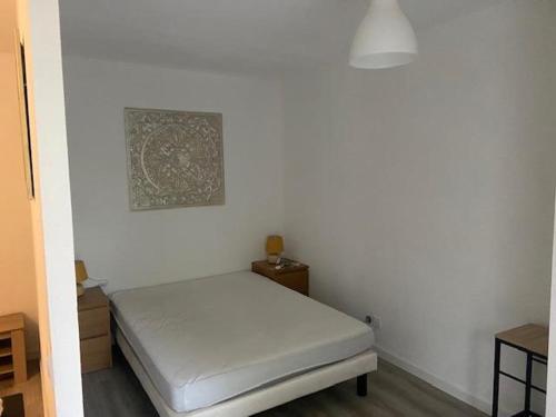 Cette chambre blanche dispose d'un lit et d'une photo murale. dans l'établissement L'instant Détente avec terrasse climatisation et parking, à Toulouse