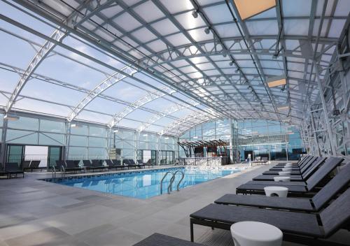 a large swimming pool with chairs and a glass ceiling at Resorts Casino Hotel Atlantic City in Atlantic City