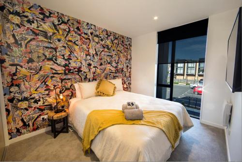 a bedroom with a large mural on the wall at Funk in the City - Luxury Laneway Apartment with Single Garage in Christchurch