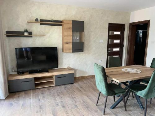 a living room with a television and a table and chairs at Tri vrbe in Ljubovija