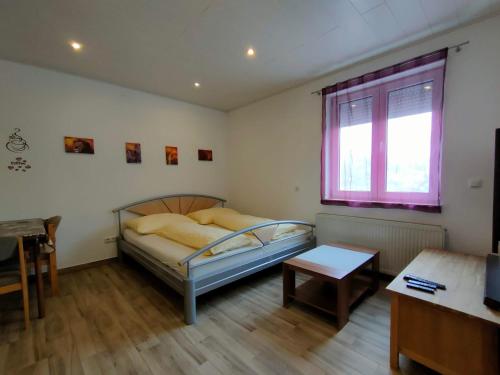 ein Schlafzimmer mit einem Bett und einem Tisch und einem Fenster in der Unterkunft Monteurzimmer mit Singleküche in Kaufing