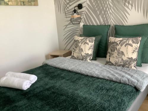 a bedroom with a bed with a green rug and pillows at Immodēly & la Magie de Disney in Serris