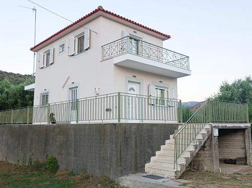 una casa blanca con una escalera delante en Zoi's Hοuse.Vacation home in Mani near Vathi beach, en Vathí