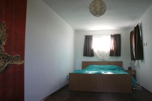 Un dormitorio pequeño con una cama y una ventana. en Villa Sanaan, en Bryastovets
