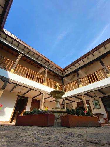 a building with a fountain in the middle of it at Hotel Campestre El Portón de Los Jeroglíficos in Ramiriquí