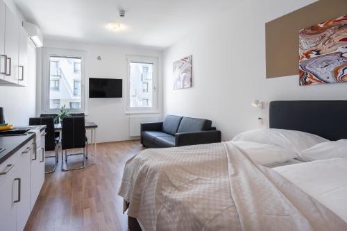 a bedroom with a bed and a desk and a kitchen at FeelGood Apartments LakeLiving inklusive Garagenplatz in Vienna