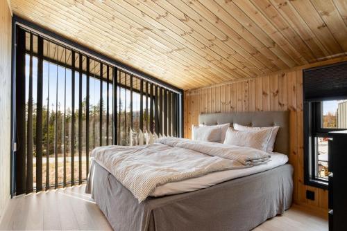 1 dormitorio con cama grande y ventana grande en Gaustablikk Hytte - MountainView, en Gaustablikk