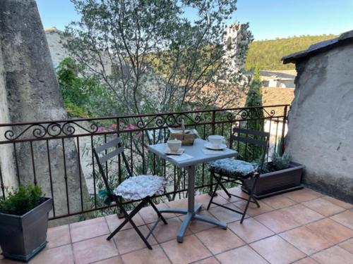 a table and chairs sitting on top of a balcony at Charmante chambre dans belle Maison typique du Village in Lagorce