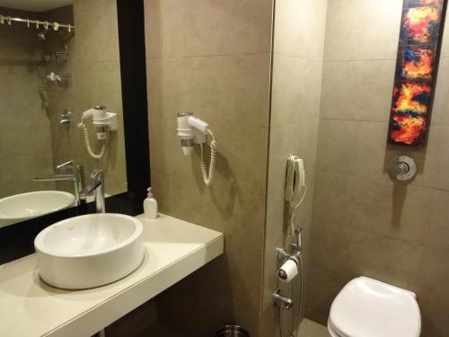 a bathroom with a sink and a shower with a phone at The Central Court in Hyderabad