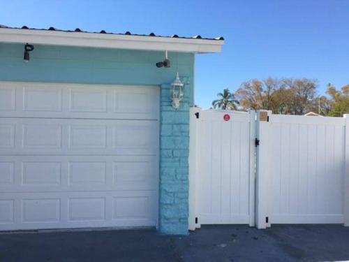 a garage with two white gates in front of a house at Sunshine in Tampa