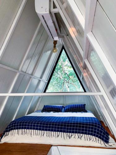 a bed in a tiny house with a window at Salto Suizo Parque Ecologico in Independencia