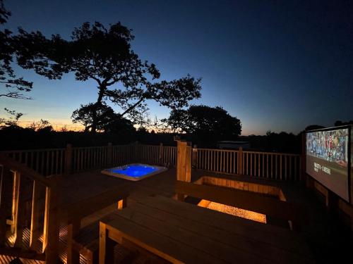 a deck with a bench and a tv on a fence at Aladdin Safari Tent in Tenby