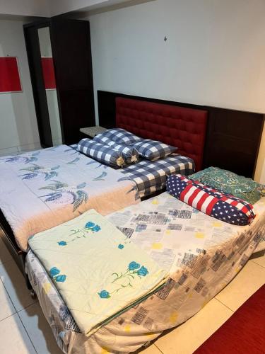 duas camas sentadas uma ao lado da outra num quarto em Sewa Apartemen Jogja MATARAM CITY em Kejayan