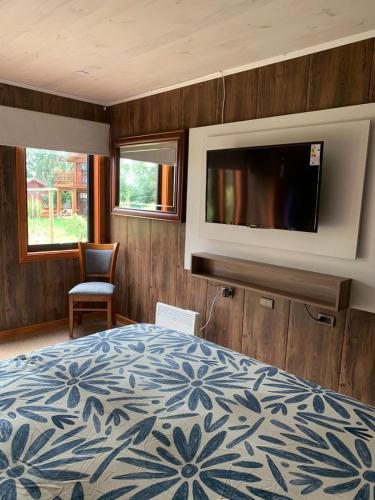 a bedroom with a bed and a flat screen tv at Hotel Boutique Family Suites in Panguipulli