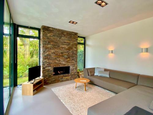 a living room with a couch and a fireplace at Heerlijk vrijstaand huis aan de duinen in Burgh Haamstede