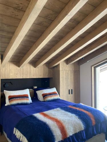 a bedroom with a large bed with colorful blankets and pillows at LE 1307 in Megève