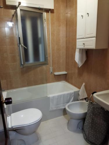 a bathroom with a toilet and a tub and a sink at Aloha Barreiros in Barreiros