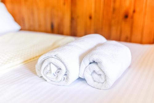 a stack of towels sitting on a bed at Eco Cottage in Kutaisi