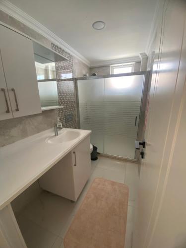 een badkamer met een wastafel en een douche met een spiegel bij CeylanHouse-3 in Dalaman