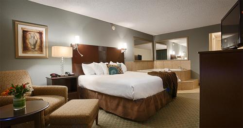 um quarto de hotel com uma cama grande e uma sala de estar em Seville Plaza Hotel, Trademark Collection by Wyndham em Kansas City