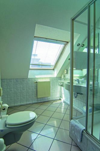 a bathroom with a toilet and a shower and a window at Akzent Hotel-Restaurant Albert in Dorsten