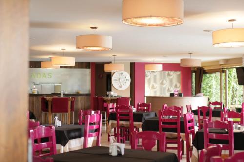 Hotel Ciudad Bonita في بوكارامانغا: غرفة طعام مع كراسي وردية وطاولات وساعة