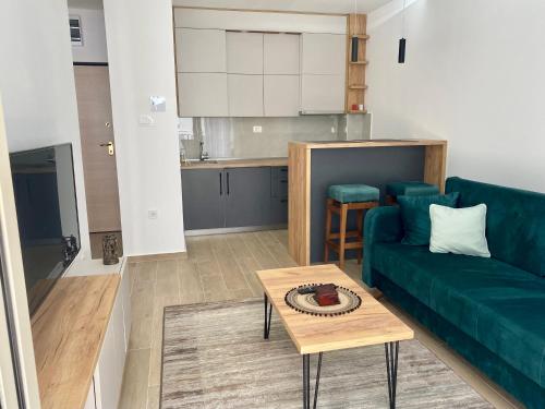ein Wohnzimmer mit einem grünen Sofa und einem Tisch in der Unterkunft Wave N' Sea Budva in Budva
