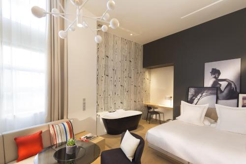 パリにあるル サンク コデのベッドルーム1室(ベッド1台付)、バスルーム(バスタブ付)が備わります。