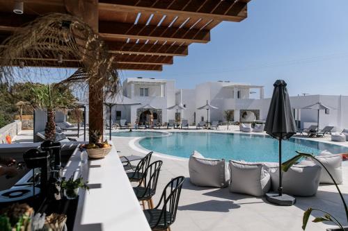 a resort with a swimming pool with tables and chairs at Cosmos Hotel in Plaka