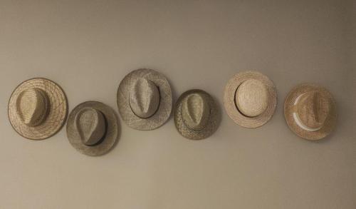 four straw hats hanging on a wall at Il Sogno in Spello