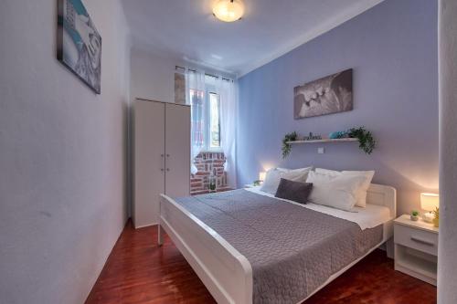 a bedroom with a large bed with blue walls at Arena city apartment in Pula