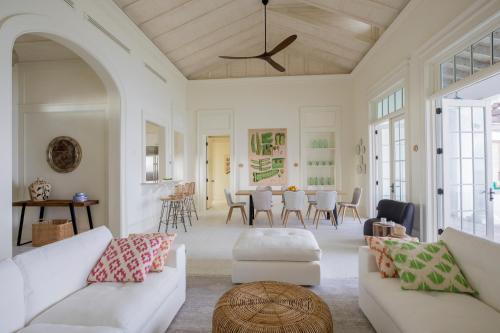 una sala de estar con 2 sofás blancos y una mesa. en Ambergris Cay Private Island All Inclusive, en Big Ambergris Cay