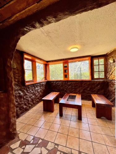 a room with two benches in a room with windows at Cabañas La Calchona in Melocotón