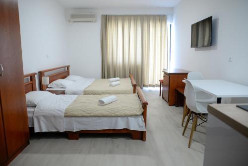 a hotel room with two beds and a desk at Villa Sandra Lagadin in Ohrid