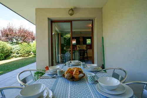 une table avec un bol de fruits dessus dans l'établissement The Maryalice charming little house next to the beach!, à Saint-Jorioz