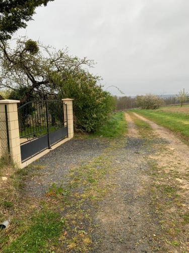 une porte sur un chemin de terre à côté d'un champ dans l'établissement loge de la Besnardière, à Mareuil-sur-Cher
