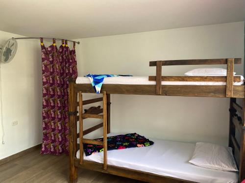 a room with two bunk beds and a curtain at XaviHostel in Bucaramanga